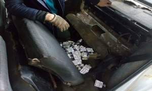Zeci de pachete de țigări de contrabandă ascunse sub bancheta din spate a unui autoturism, descoperite de polițiștii de frontieră de la Vama Stânca